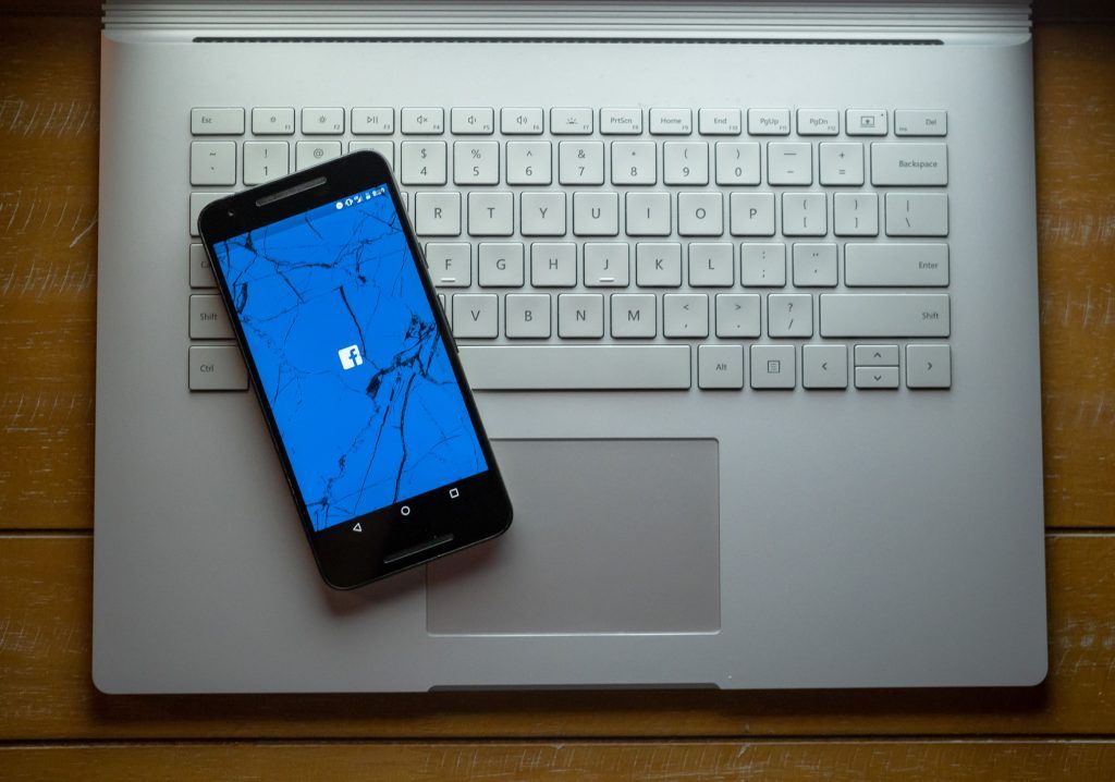 Facebook app on a smartphone with a cracked screen