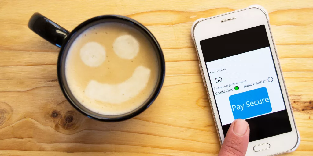 Notification of a secure payment on a smartphone. An up-close view of a wooden desk.